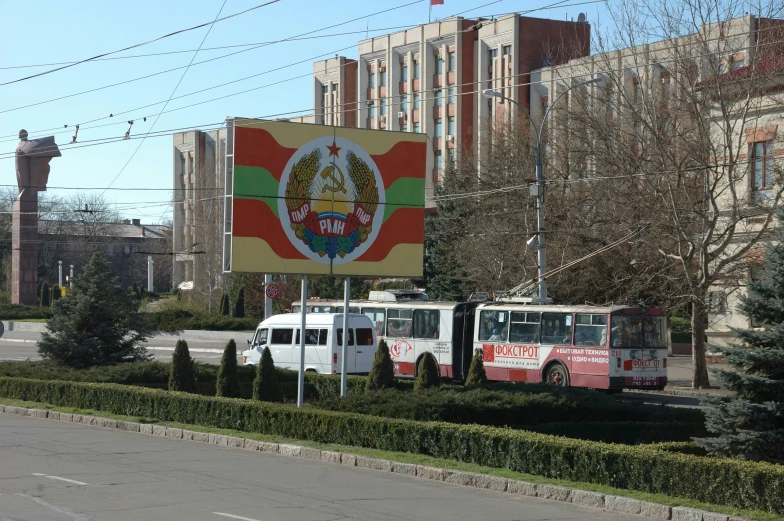 two buses are parked in front of a sign