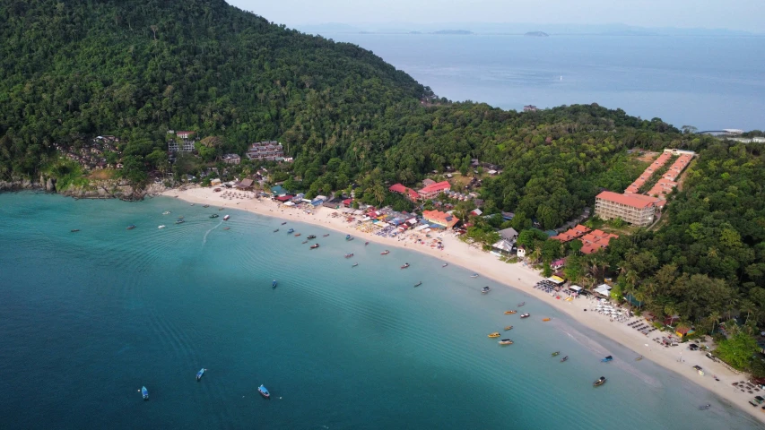 a large beach next to a mountain with boats in it