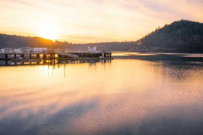 the sun shines on a lake at sunset