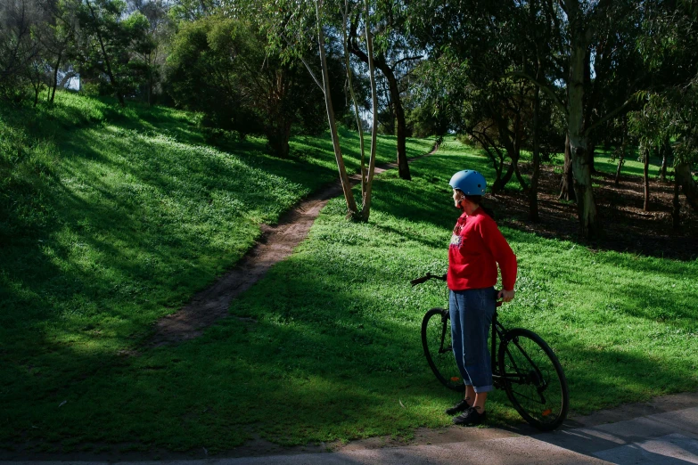 the person in red jacket is standing with a bike