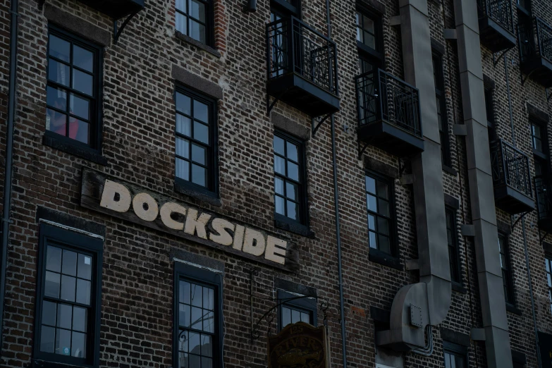 an image of brick building with windows and a clock on the side