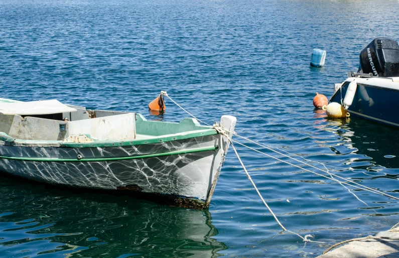 small white boat tied up to the dock