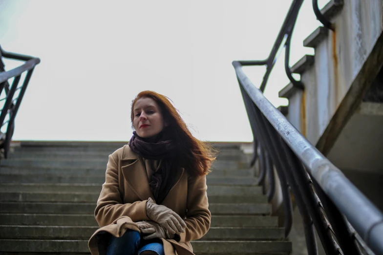 a young woman sitting on the steps at a stairside