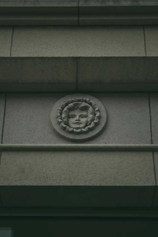 a face carved into the side of a stone building