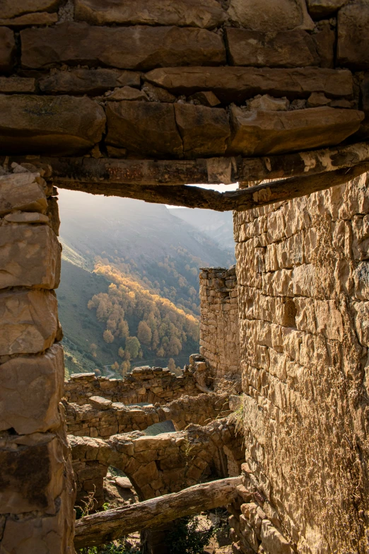 the window in the stone house is looking out on the valley