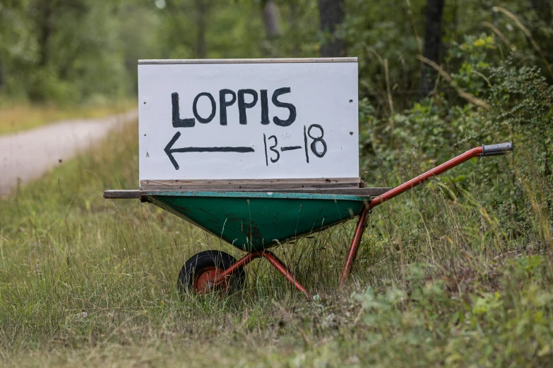 a small wheelbarrow with the word jolpis on it in front of a dirt road