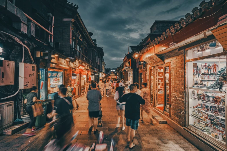 several people walk down a busy street at night