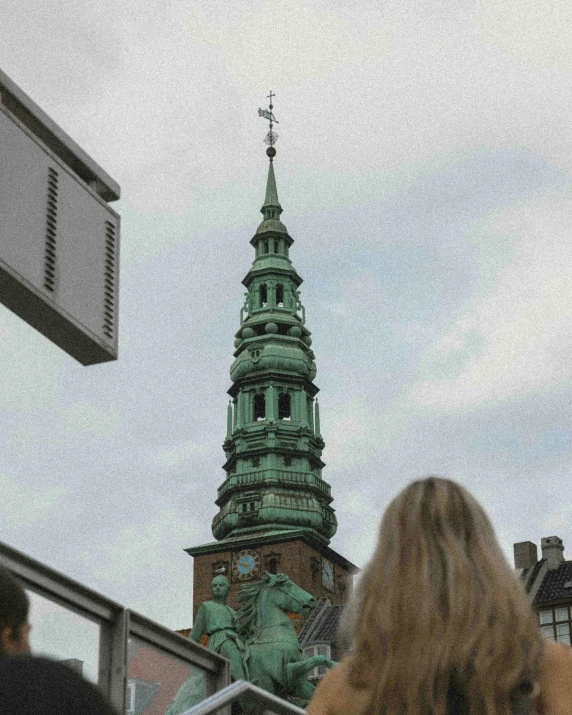 people are looking up at the tall building with a large tower