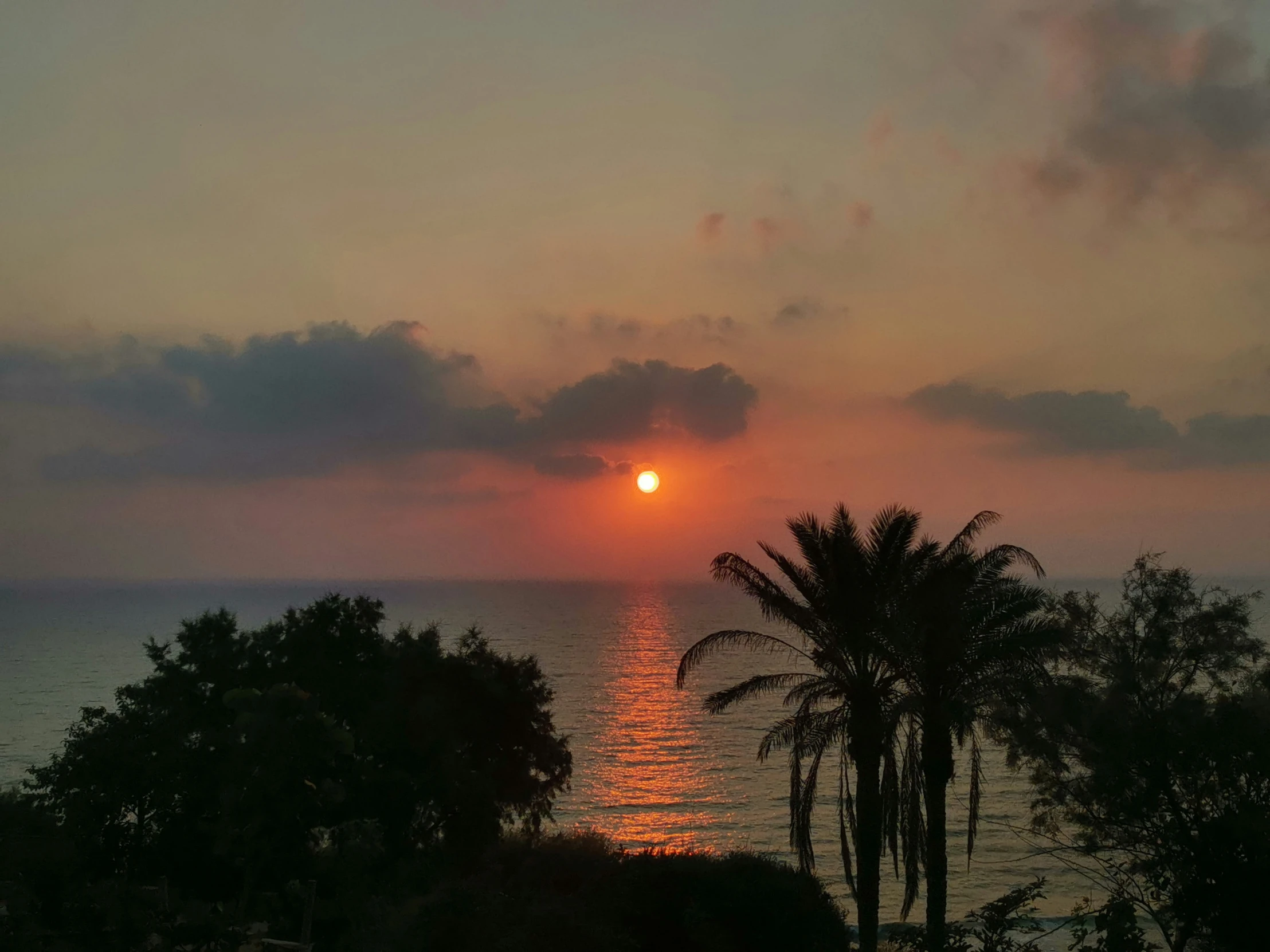 the sun setting over water in an open sky area