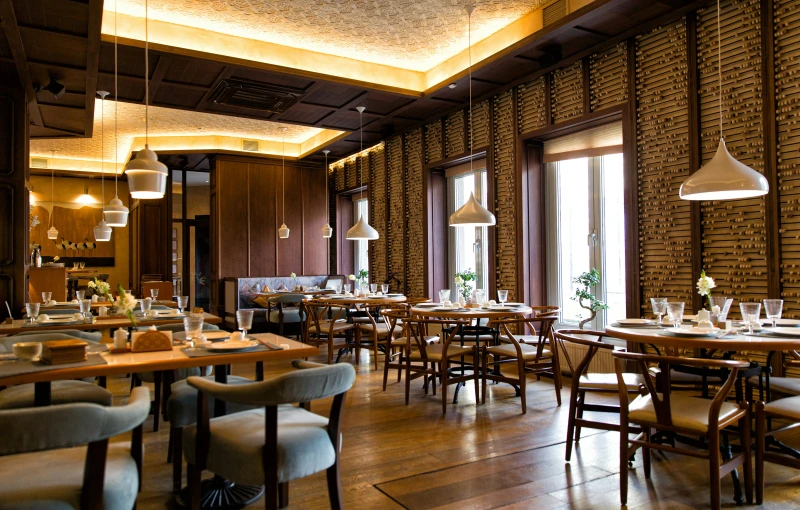 an elegant restaurant with high back chairs, a wooden floor and walls decorated in different styles