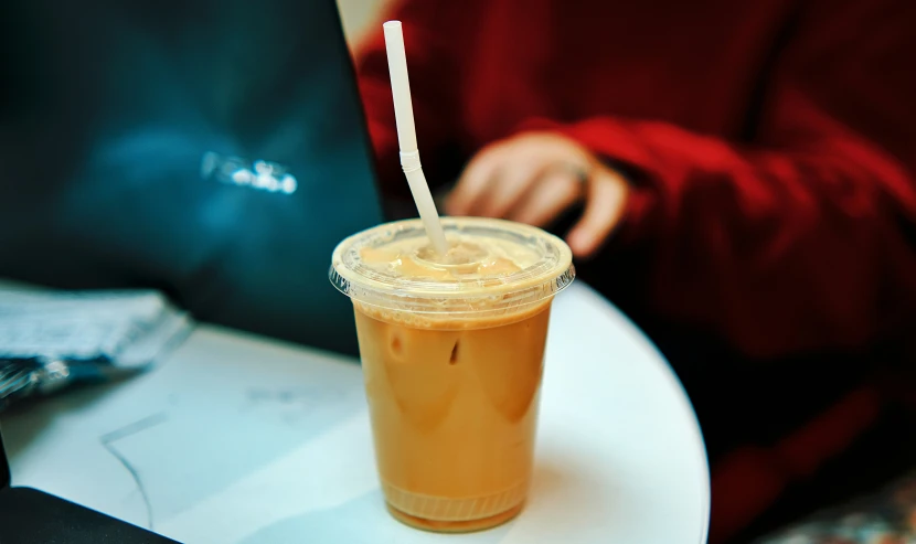 a cup with a straw sitting on a white table