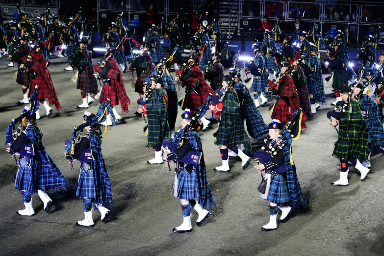 a large group of people in kilts on a street