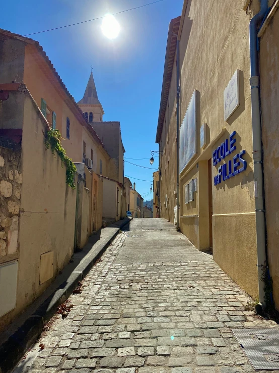 cobblestone street with a sun above the building