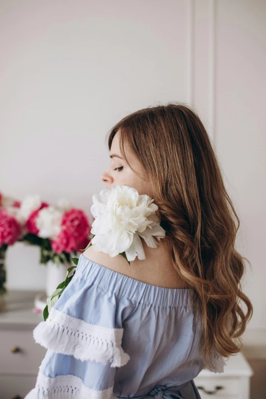 a woman standing in front of some flowers