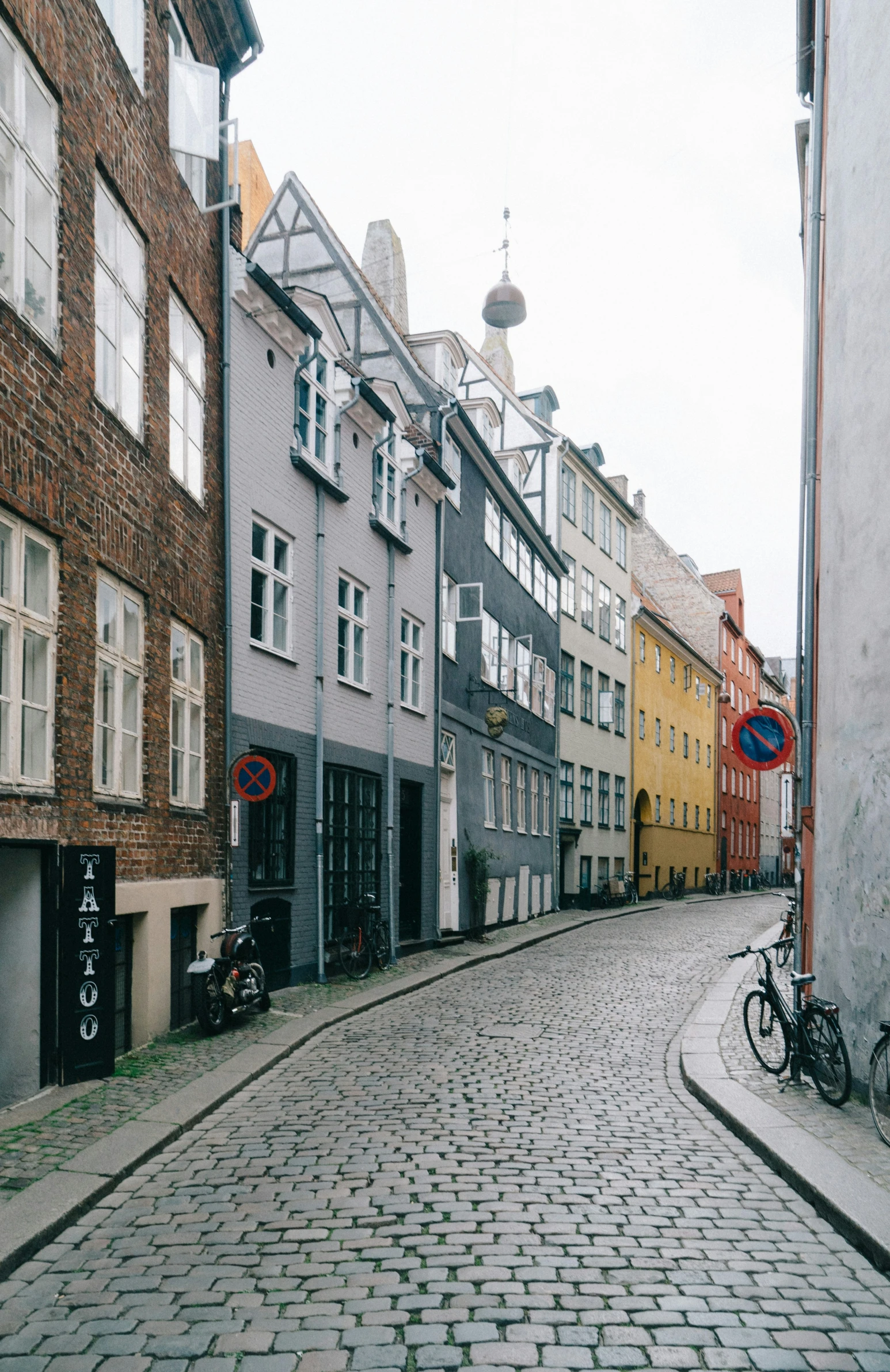 a cobblestone street with multiple brick buildings and bicycle parked next to it