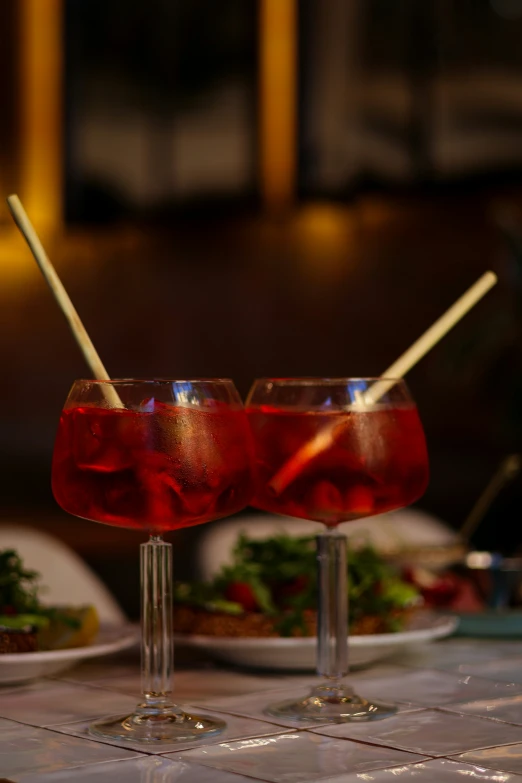 two cocktails with strawberries sit on the table