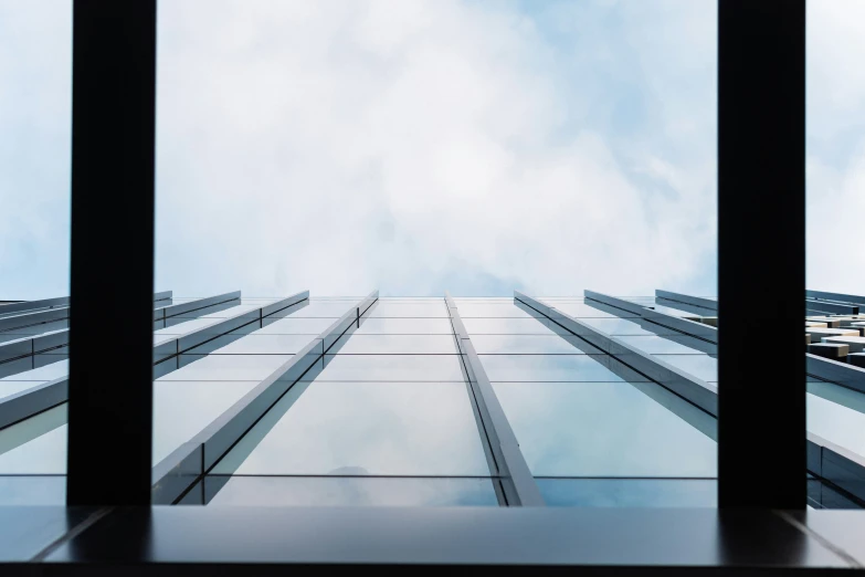 a large glass office building with sky in background
