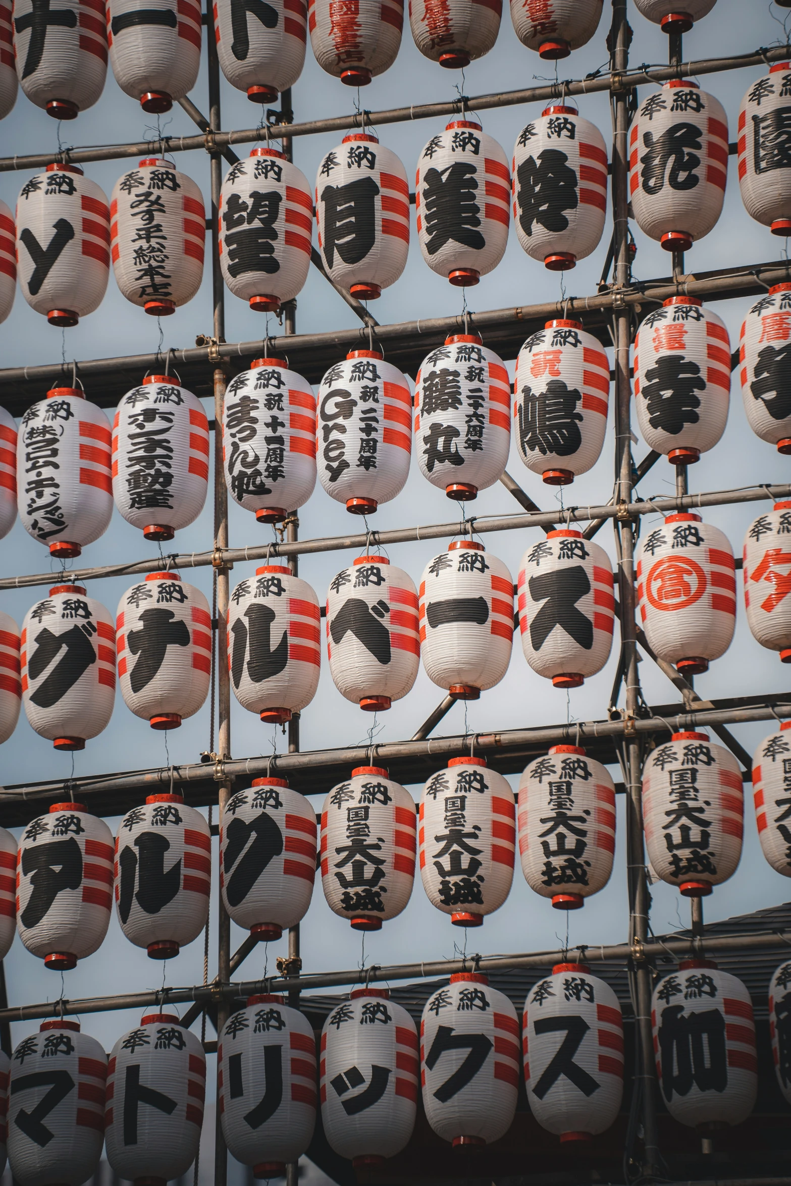 many japanese hanging lanterns on the side of a building