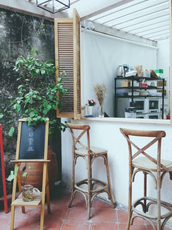 some brown chairs a white wall and some plants