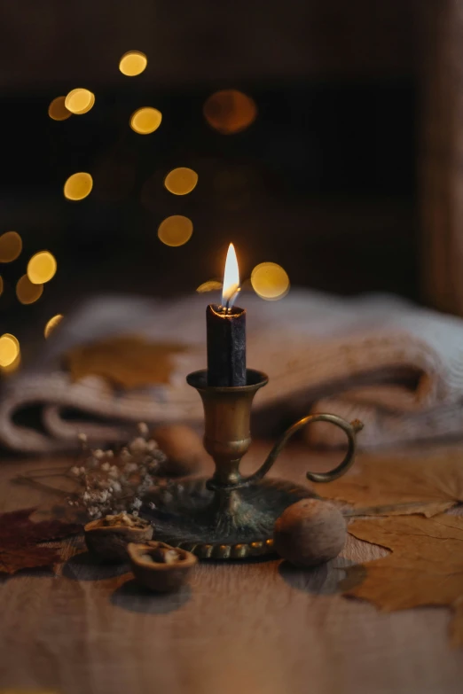 a small candle on a table with some lights in the background