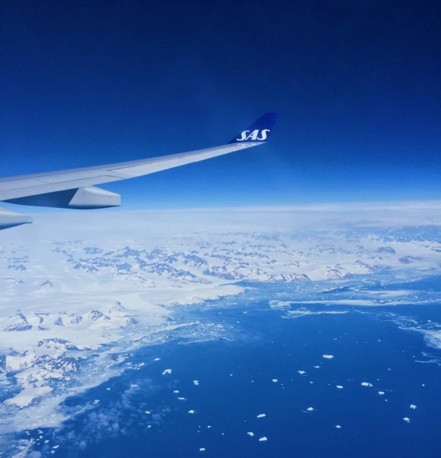 a airplane wing above some snow and ice