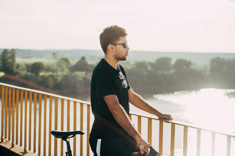 a man standing next to a balcony with a bike