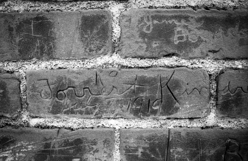 graffiti on an old brick wall in black and white