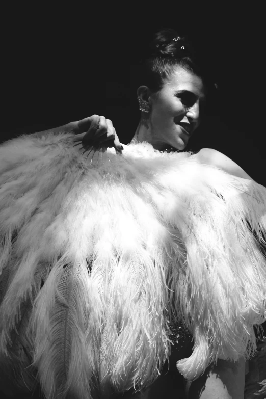 a woman wearing a feathery coat on her left side