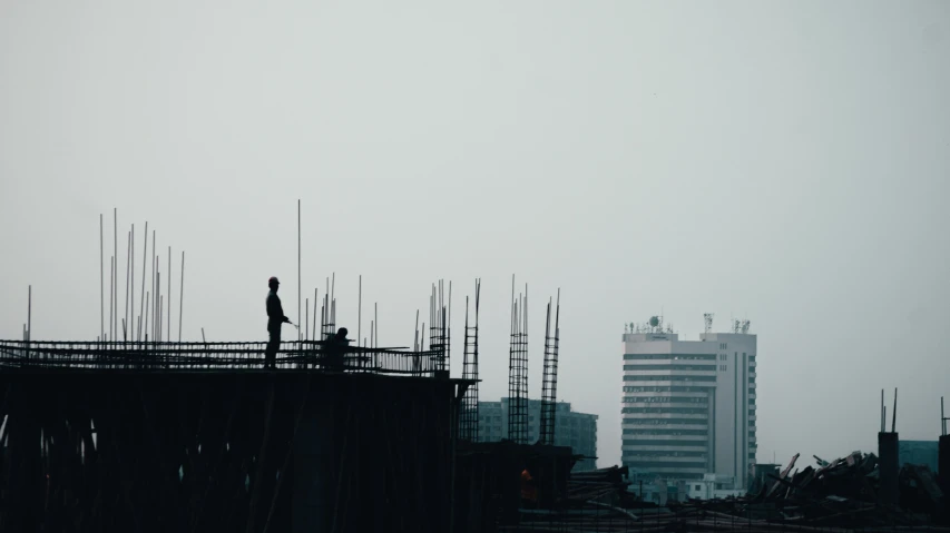 a tall building under construction in front of some buildings