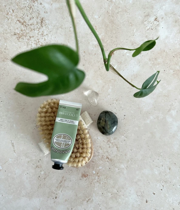 a bottle of lotion sitting on top of a floor next to a rock