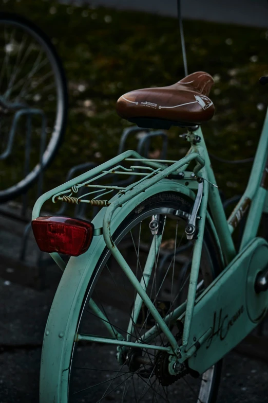 a bicycle with an old fashioned seat sitting on the side of the street