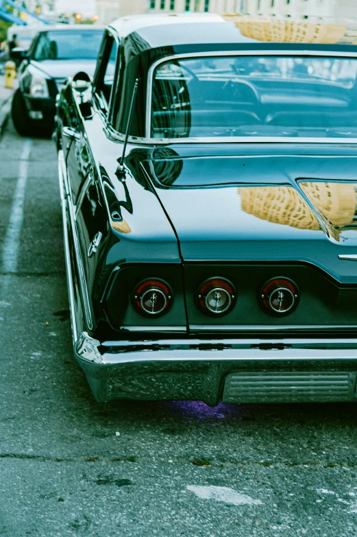 an old muscle car sits parked near some cars