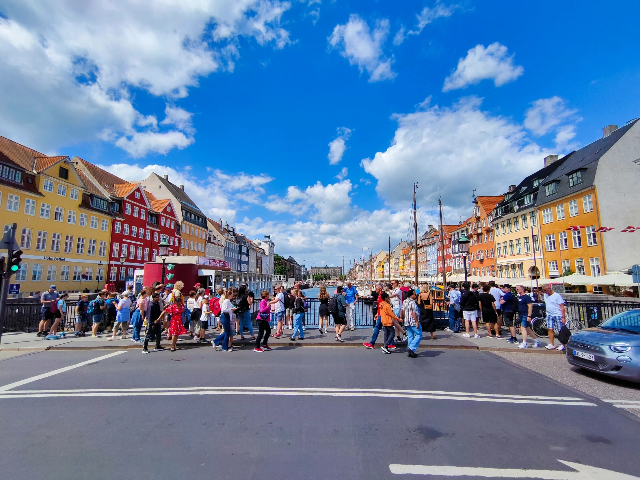 many people are standing on the corner by the street