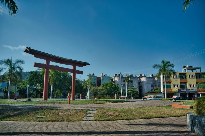 a wooden object near a small road with palm trees