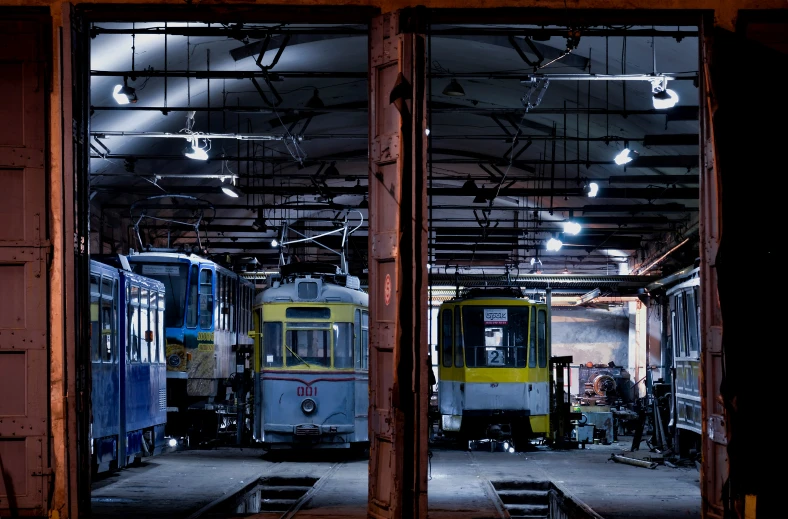 two trains in a warehouse with their doors open