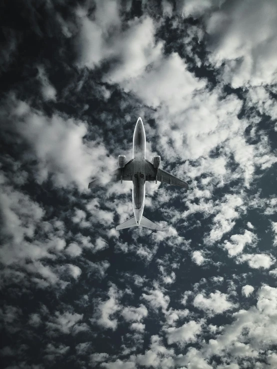 a jetliner flying through the clouds in a cloudy sky