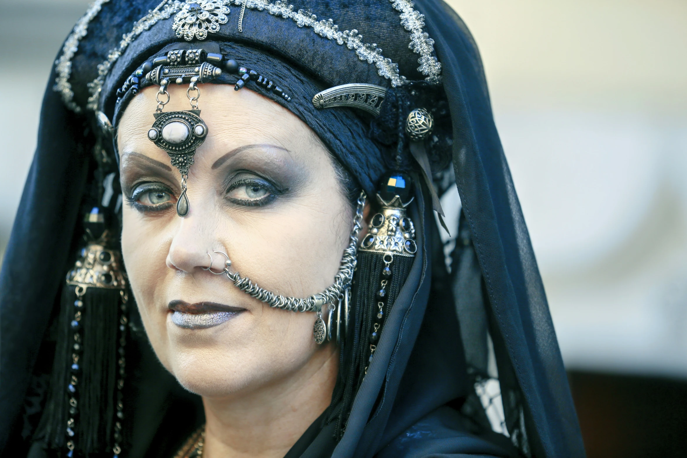 an older woman wearing a headscarf and dressed in silver