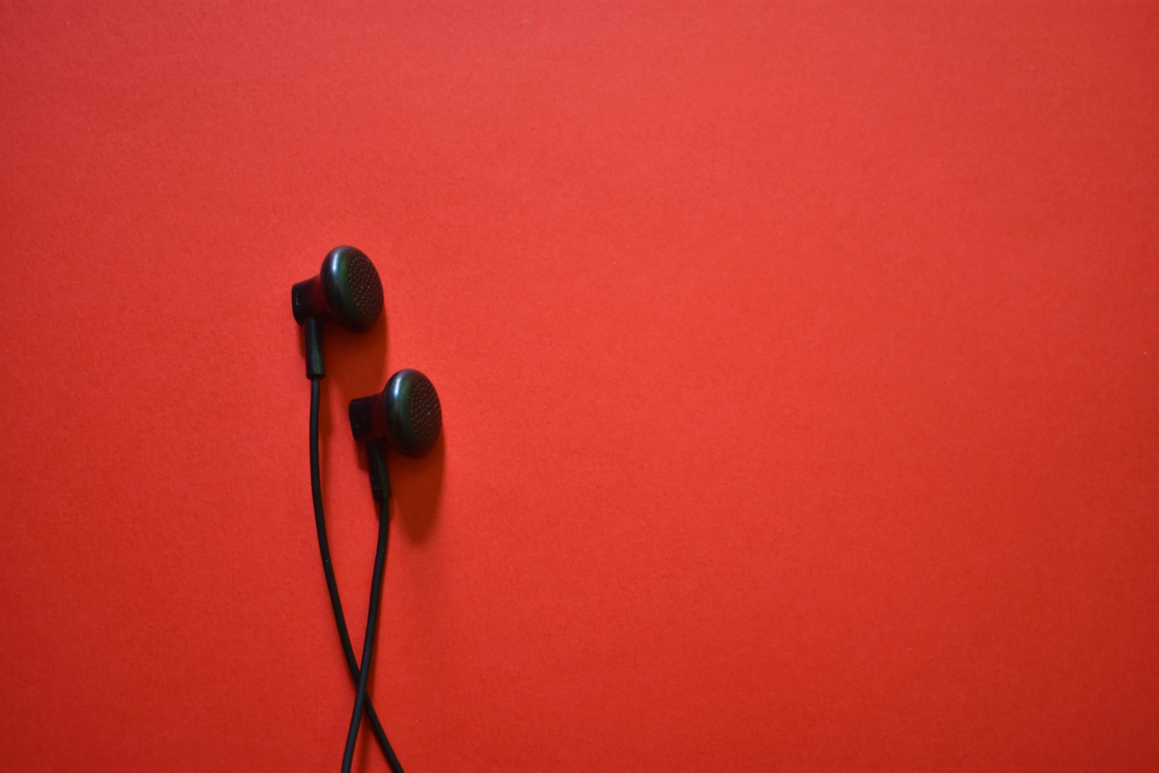 there are ear phones that are placed against the red surface