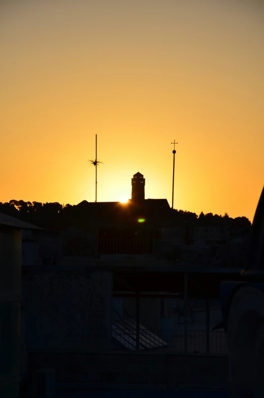 the sun setting in a city with an orange sky