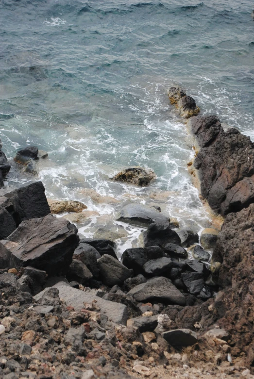 a rocky shore with very small rocks and the ocean