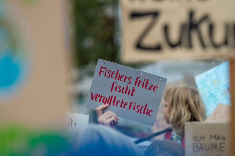 some people holding up signs and boxes for food