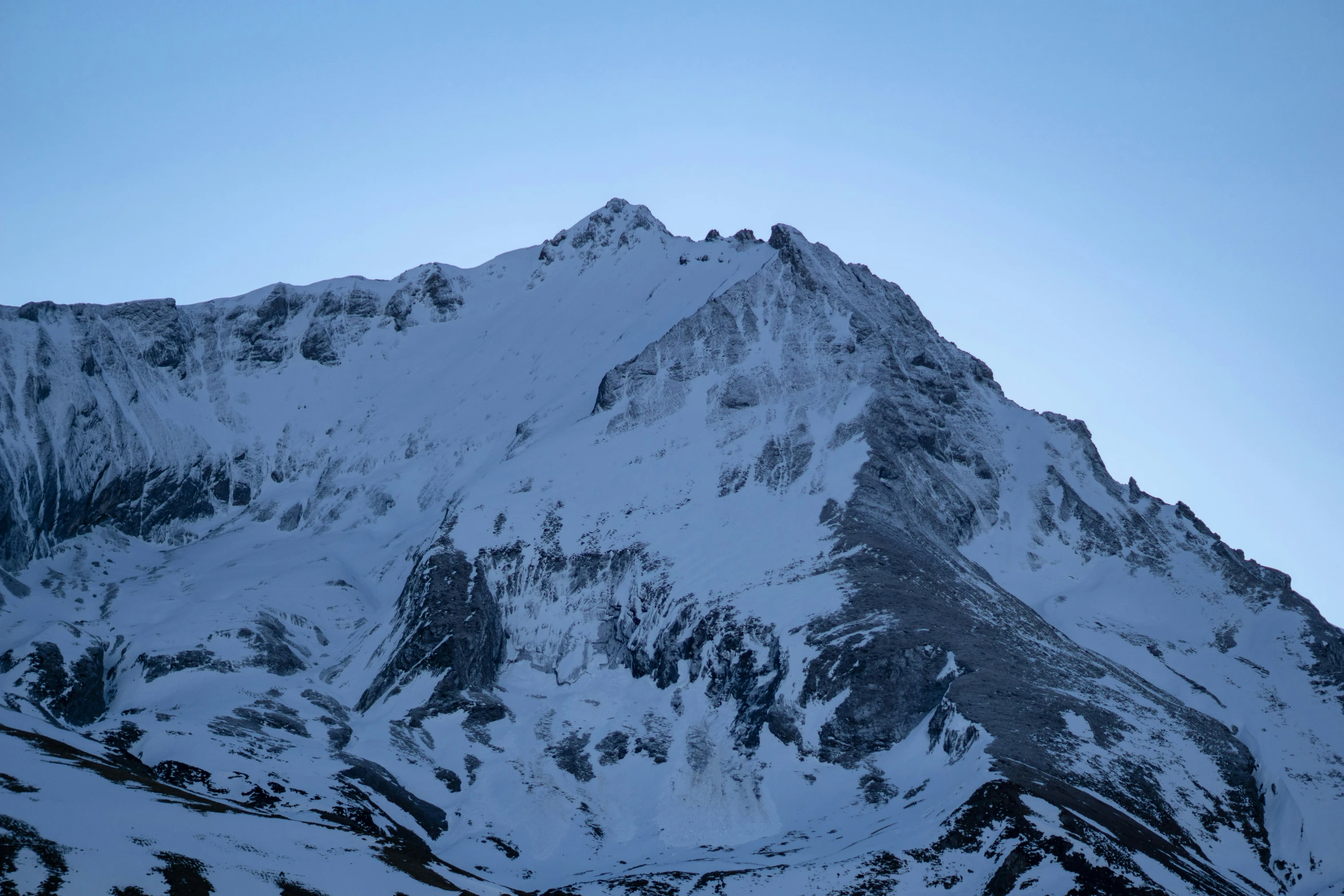 mountains covered in snow under a blue sky