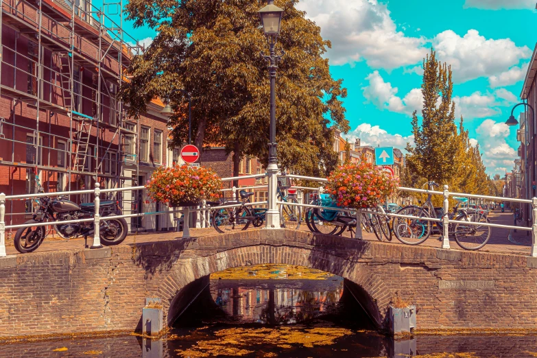 flowers and bicycles decorate the top railings of this brick bridge