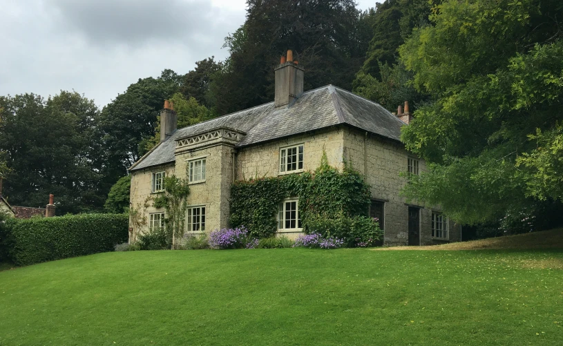 a tall house sitting on top of a lush green field