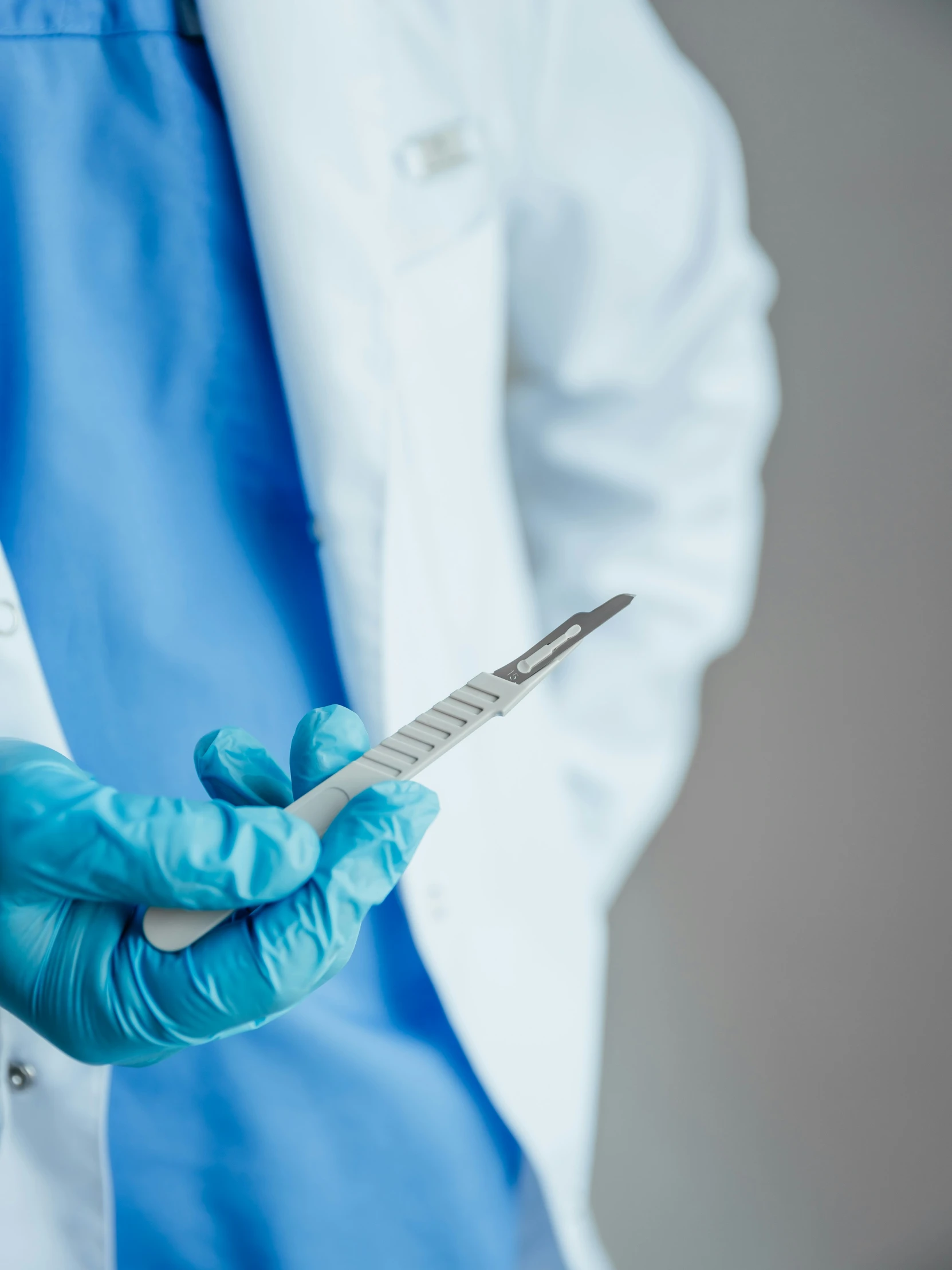 someone in white coat and green gloves holding an iv