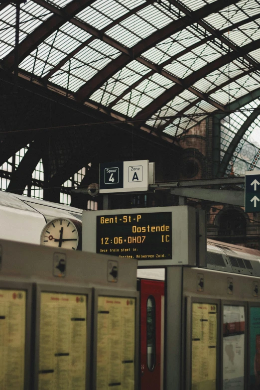 train station with signs and a clock showing the time