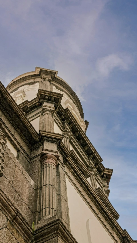 a tall building with a clock and a sky in the background