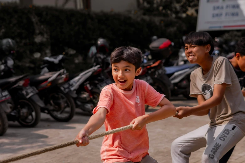 two boys playing tug of war in the street