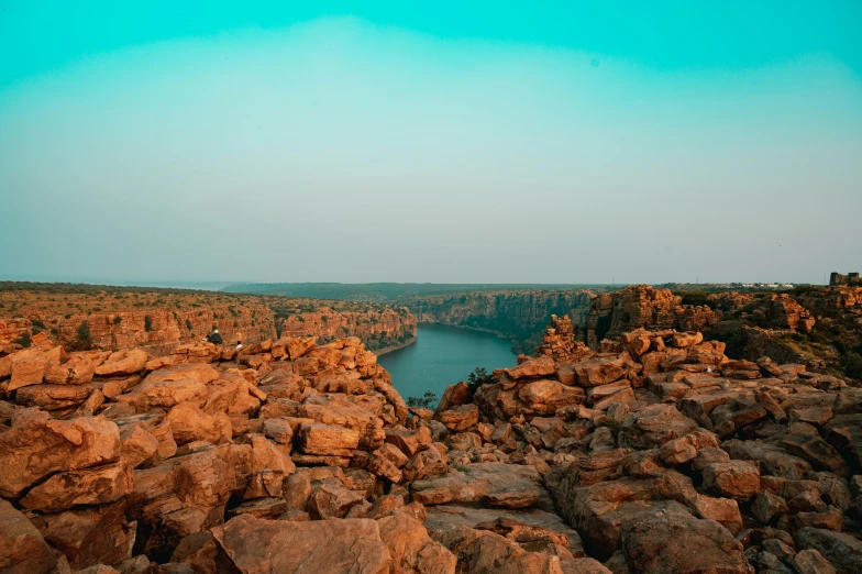 a rocky area with lake surrounded by trees and water