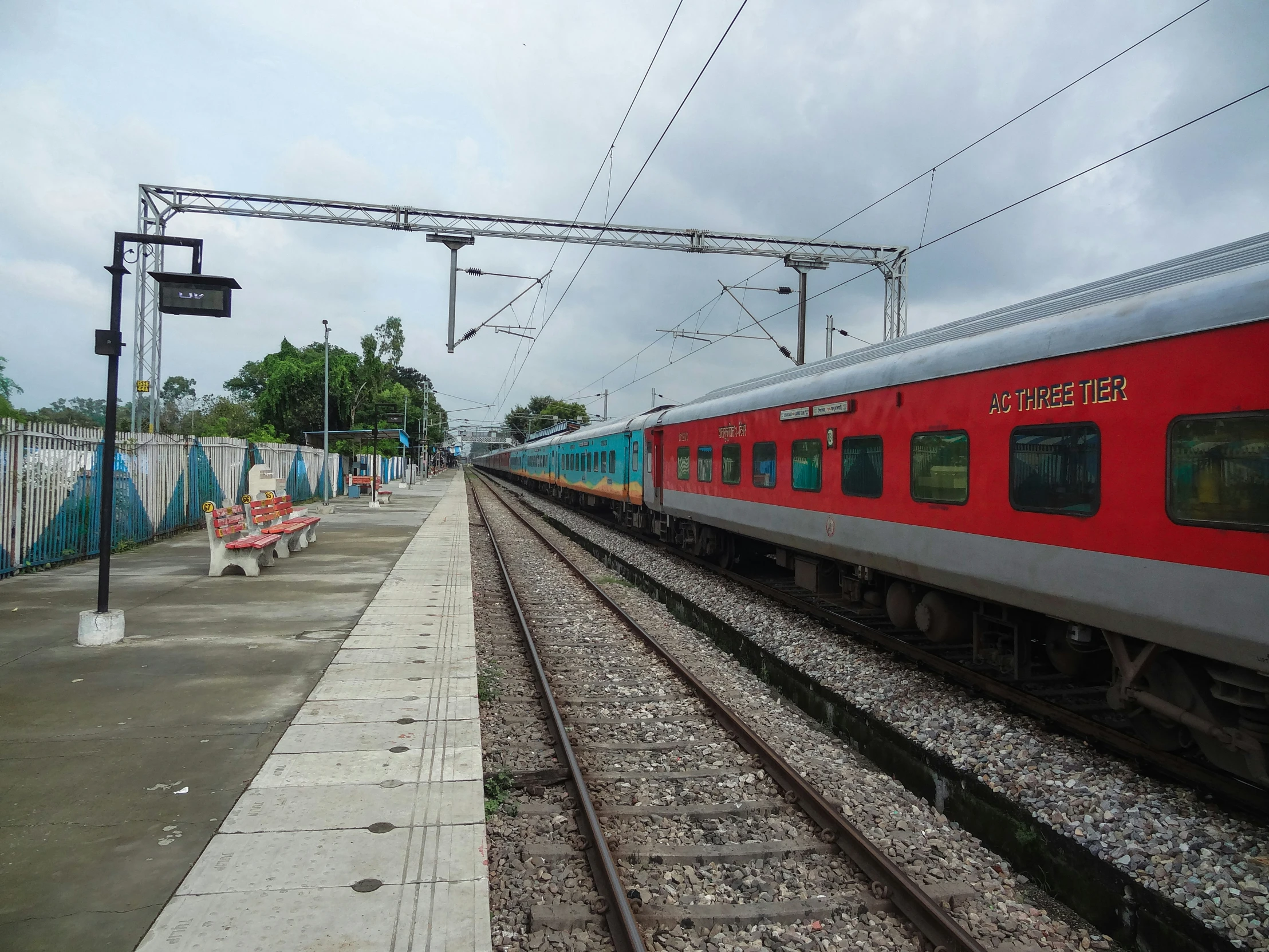 the train is approaching a stop on a cloudy day